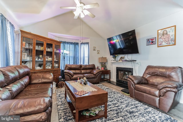 living room with ceiling fan, plenty of natural light, light hardwood / wood-style flooring, and lofted ceiling