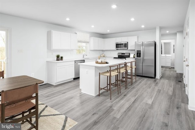 kitchen featuring white cabinetry, appliances with stainless steel finishes, a healthy amount of sunlight, and a center island