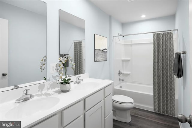 full bathroom with vanity, hardwood / wood-style flooring, toilet, and shower / tub combo