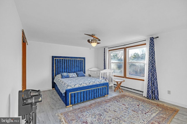 bedroom featuring hardwood / wood-style floors and a baseboard radiator