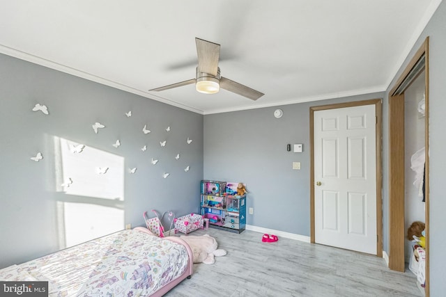 bedroom featuring ceiling fan, light wood-type flooring, and crown molding