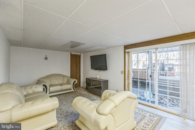 living room featuring a paneled ceiling and light wood-type flooring