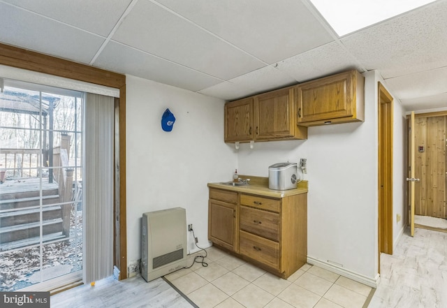 kitchen with a paneled ceiling and heating unit