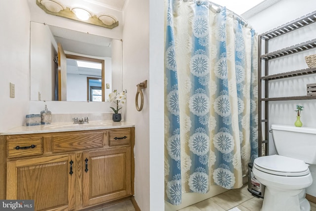 bathroom with tile patterned flooring, vanity, and toilet