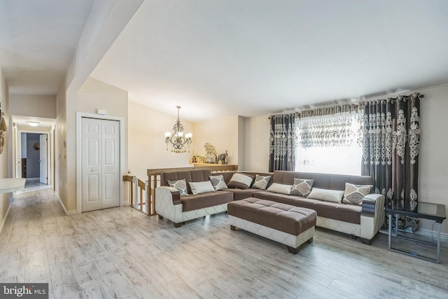 living room featuring a chandelier, light wood-type flooring, and vaulted ceiling