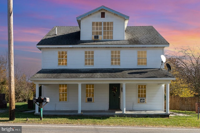 view of front of house with a porch and a yard