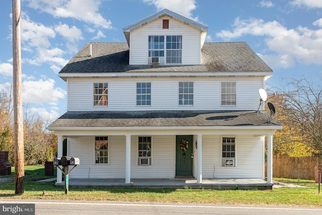 view of front of home featuring a front yard, cooling unit, and a porch