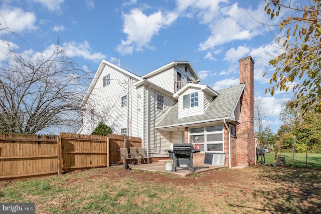 back of house with a patio and a yard