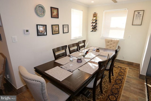 dining area featuring dark wood-type flooring and crown molding