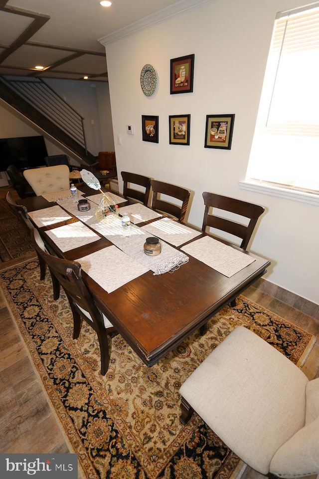 dining space with ornamental molding, plenty of natural light, and hardwood / wood-style flooring