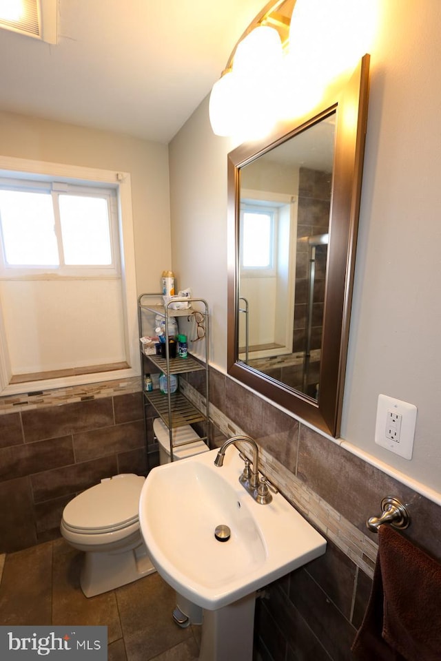 bathroom featuring tile walls, tile patterned flooring, sink, and toilet