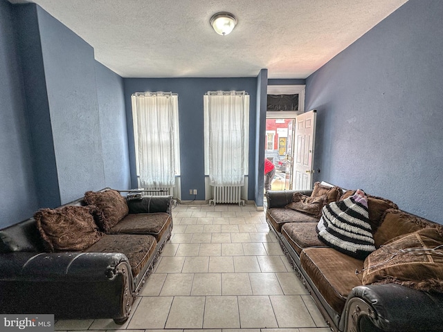 tiled living room with a textured ceiling and radiator