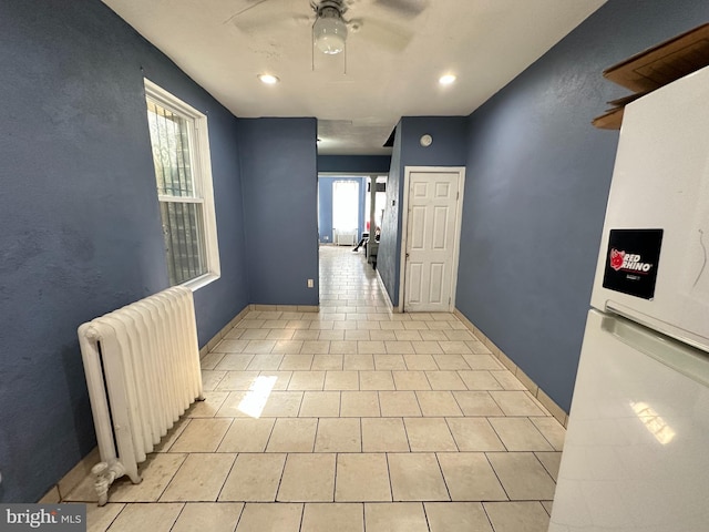 hall featuring radiator and light tile patterned floors