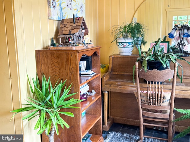 interior details featuring tile patterned flooring and wooden walls