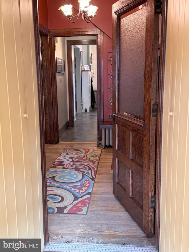 hall featuring a chandelier and hardwood / wood-style flooring