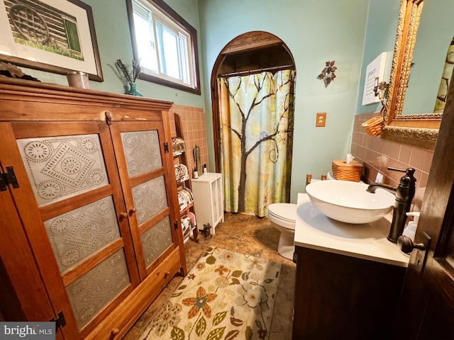 bathroom featuring radiator, curtained shower, toilet, vanity, and tile walls