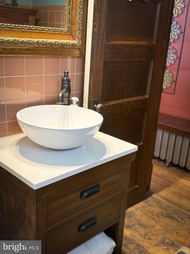 bathroom with vanity, tile walls, and backsplash