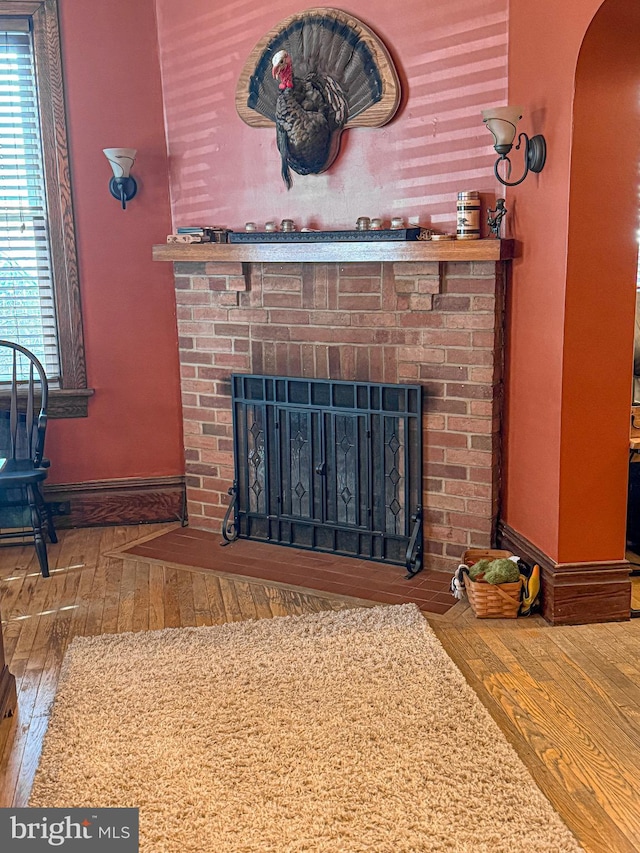 interior details featuring hardwood / wood-style floors and a brick fireplace