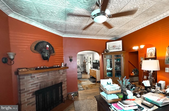 interior space featuring hardwood / wood-style floors, a brick fireplace, and ceiling fan