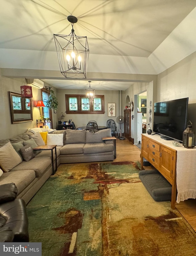 living room featuring hardwood / wood-style floors, a notable chandelier, and lofted ceiling