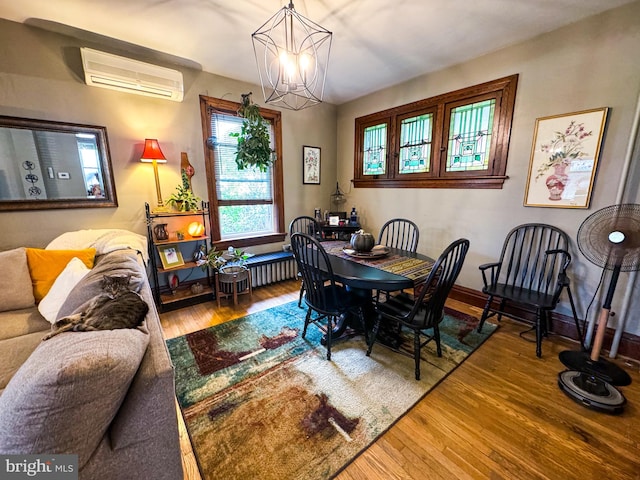 dining room featuring an inviting chandelier, hardwood / wood-style flooring, an AC wall unit, and radiator