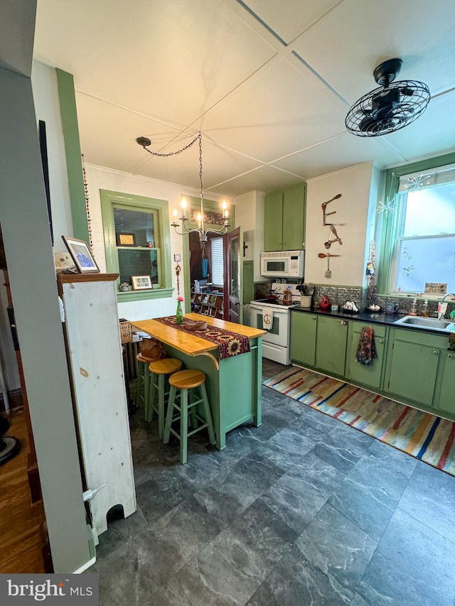 kitchen with a breakfast bar, white appliances, wooden counters, green cabinets, and sink