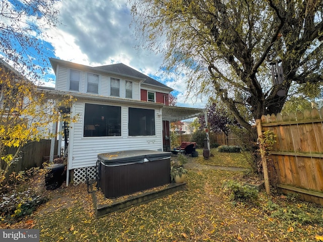 back of property featuring a hot tub