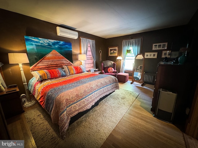 bedroom featuring a wall mounted AC, wood-type flooring, and radiator