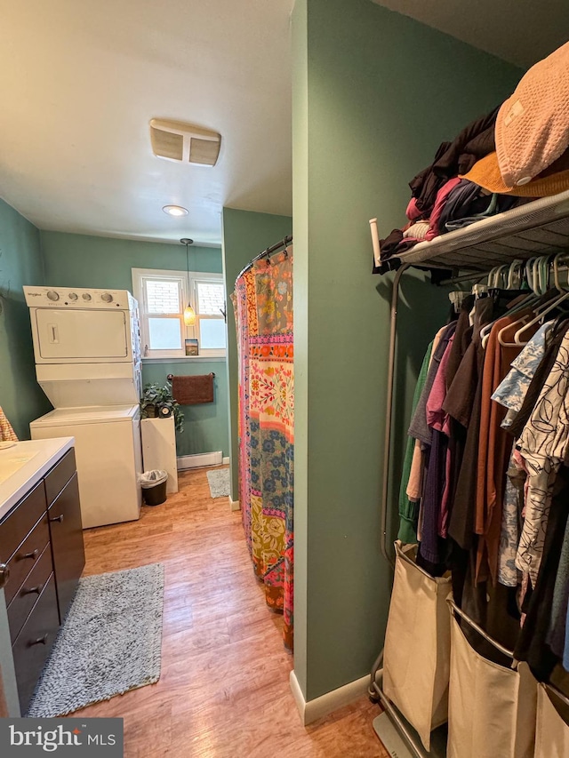 interior space with light wood-type flooring and stacked washer / dryer