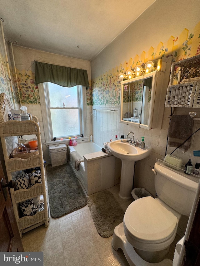 bathroom featuring a tub, tile walls, and toilet