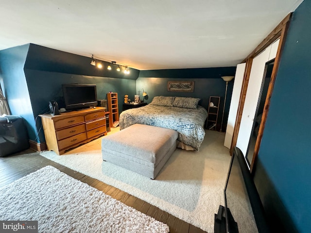 bedroom featuring track lighting and light hardwood / wood-style flooring