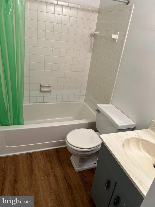 full bathroom with hardwood / wood-style floors, vanity, shower / bath combination with curtain, and toilet