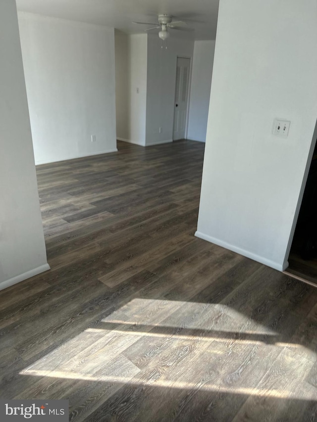 empty room with ceiling fan and dark hardwood / wood-style flooring