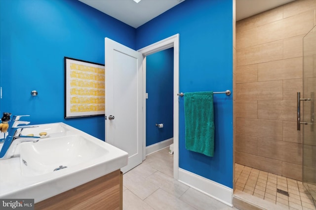 bathroom with vanity, tile patterned floors, and tiled shower