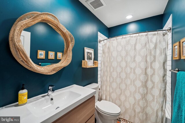 bathroom with a shower with shower curtain, vanity, and toilet