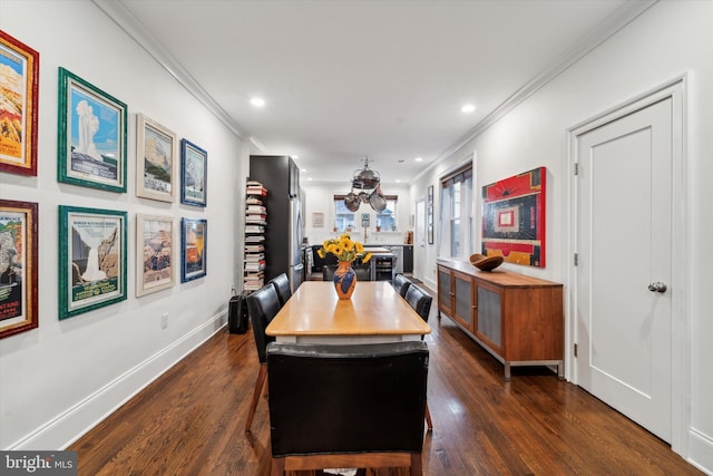 dining room with dark hardwood / wood-style flooring and crown molding