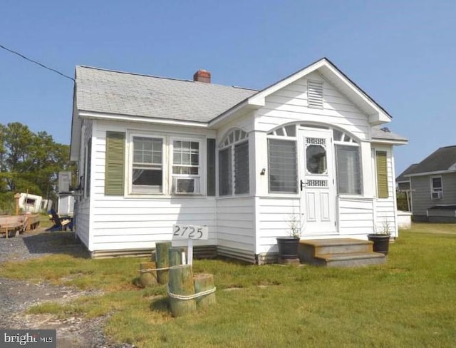 rear view of property with a sunroom and a lawn