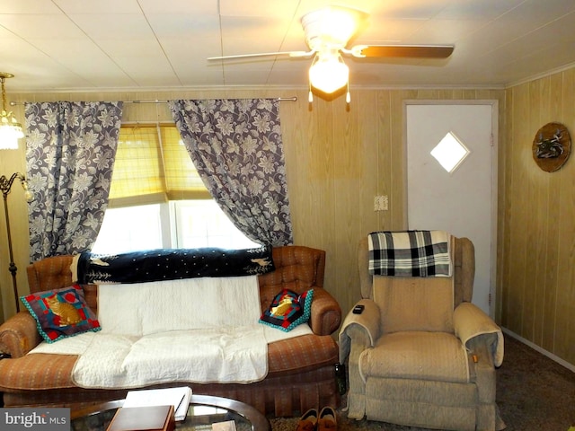 living room featuring wooden walls, crown molding, and ceiling fan