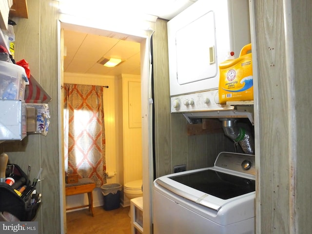 clothes washing area with stacked washing maching and dryer