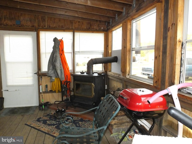 interior space featuring lofted ceiling with beams and a wood stove