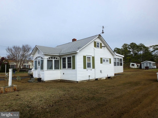 view of side of property with a sunroom and a yard