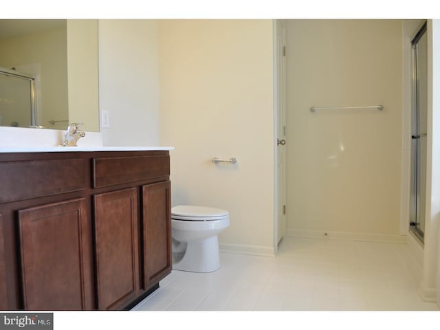 bathroom featuring vanity, toilet, and a shower with shower door