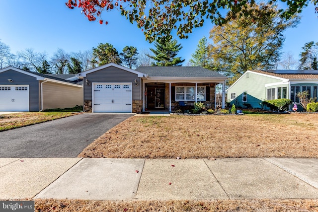 ranch-style home with a garage, a front lawn, and covered porch