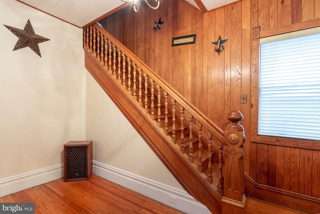 stairway with wood-type flooring and wooden walls