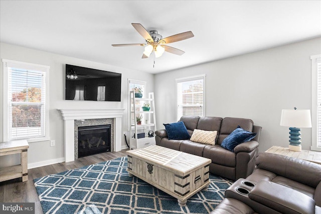 living room with dark hardwood / wood-style flooring, a wealth of natural light, and ceiling fan