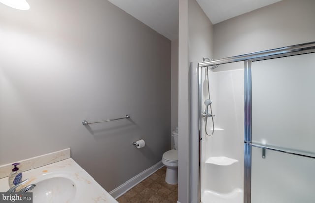 bathroom featuring vanity, toilet, and an enclosed shower