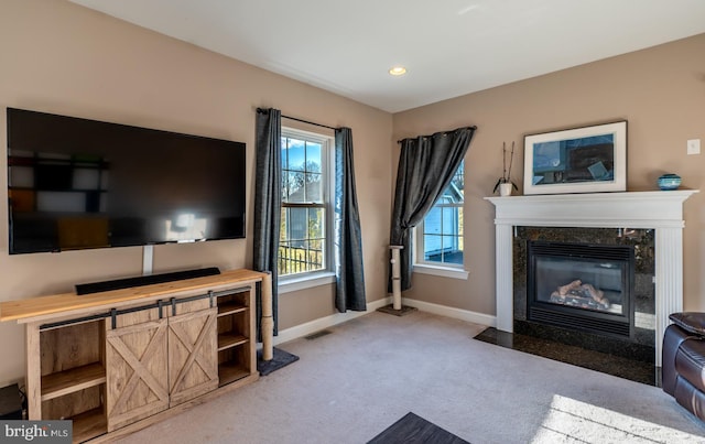 living room featuring light carpet and a high end fireplace