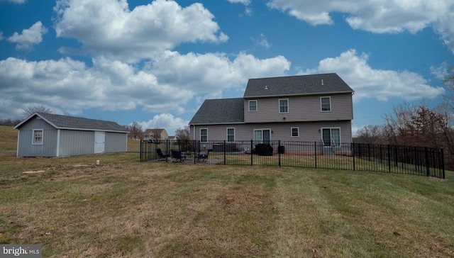 rear view of house featuring an outdoor structure and a yard