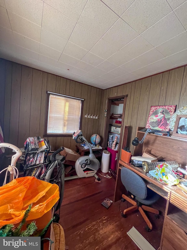 office area with wooden walls and wood-type flooring