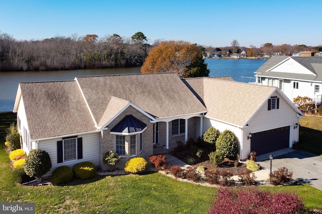 single story home with a water view, a garage, and a front lawn